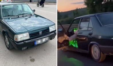 Otomobilinin sol ön kapısını açıp ayağıyla tutarak trafikte ilerledi