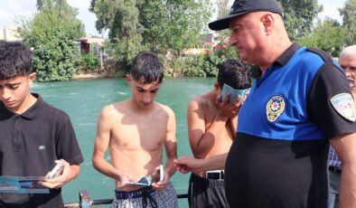 Tehlikeye aldırmadan kanalda serinleyen çocukları polis çıkardı, ailelerine ceza yazdı